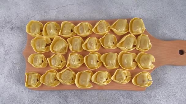 Syrové nevařené tortelloni s houbovou náplní na dřevěné desce. — Stock video