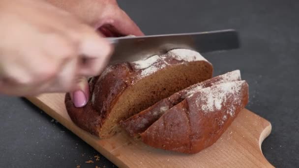Крупним планом Жіночі руки ріжуть свіжий житній хліб ножем — стокове відео