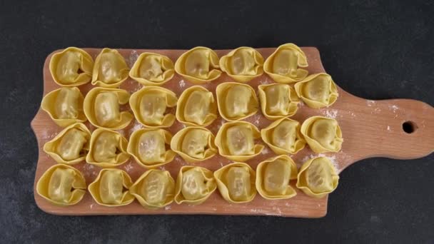 Okokt rå tortelloni med svamp fyllning på en träskiva. — Stockvideo