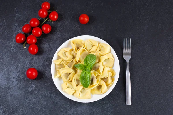 Hausgemachte italienische Tortelloni mit frischem Basilikum auf einem Teller. — Stockfoto