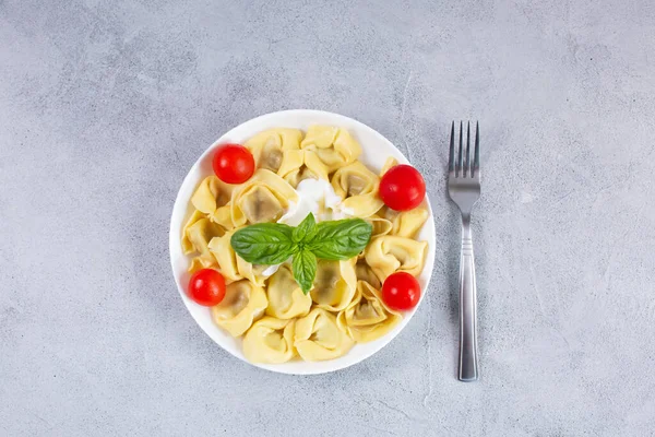 Hausgemachte italienische Tortelloni mit frischem Basilikum auf einem Teller. — Stockfoto