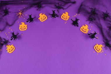 Örümcek ağlı Cadılar Bayramı arkaplanı, örümcekler ve mor arka planda gülümseyen Jack..