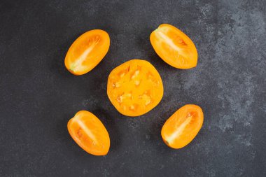 Siyah zemin üzerinde taze sarı turuncu domatesler..