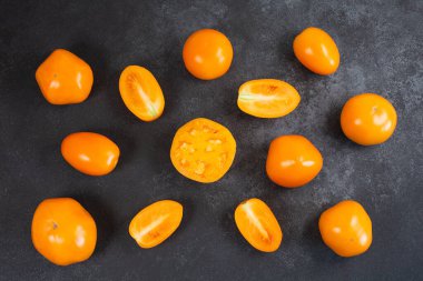 Olgun taze turuncu domates deseni siyah arkaplanda.