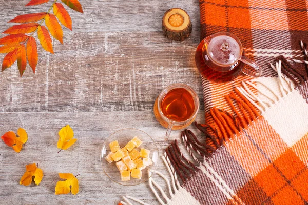 Home desk table with checkered orange plaid and tea cup, fall leaves — Stock Photo, Image