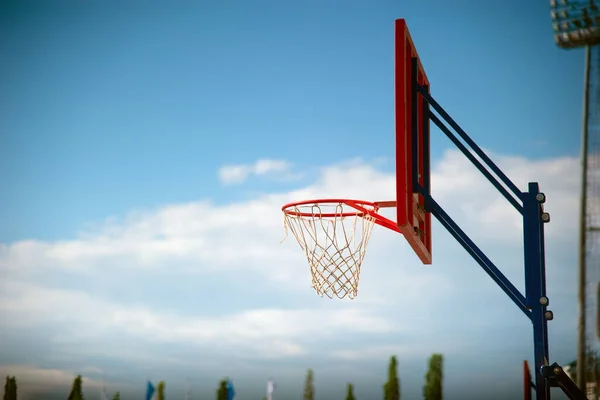 Basketball hoop with a red backboard on a blue sky background. — Zdjęcie stockowe