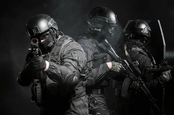 Żołnierz sił specjalnych jako część grupy sił specjalnych osłania tył, celuje w kamerę celownikiem laserowym. — Zdjęcie stockowe