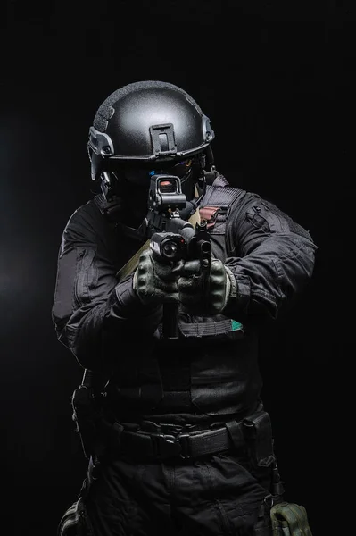 Militär man i stridsutrustning med vapen på svart bakgrund. — Stockfoto