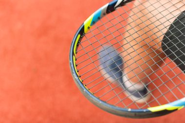 Tenis raketi kırmızı bir suni sahanın arka planına yakın plan, fotokopi alanı ile