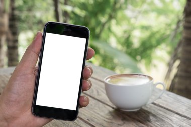 Akıllı telefonu boş cep telefonu ve kahve fincanı olan bir adamı kapat. Boş ekranlı bir market telefonu ve akıllı telefondan mesajlarınızı ekleyebilirsiniz..