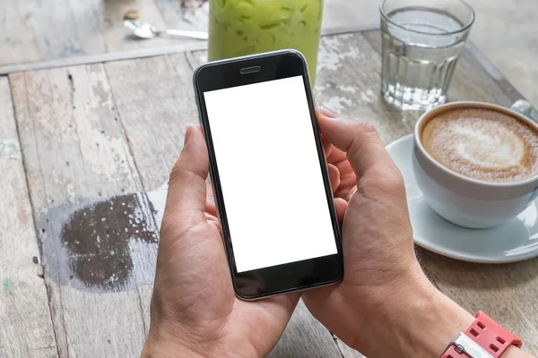 Primer plano de un hombre que utiliza el teléfono inteligente con el móvil en blanco y la taza de café. Teléfono inteligente con pantalla en blanco y se puede agregar sus mensajes de texto u otros en el teléfono inteligente . — Foto de Stock