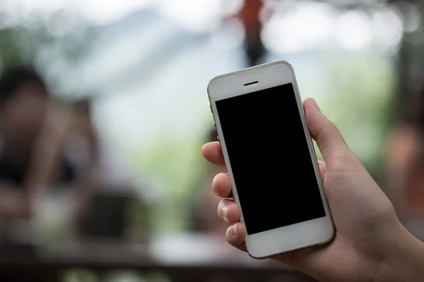 Primer plano de una mujer que usa un teléfono inteligente con un móvil en blanco y una taza de café. Teléfono inteligente con pantalla en blanco y puede agregar sus mensajes de texto u otros en un teléfono inteligente . —  Fotos de Stock