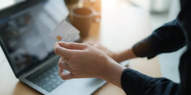 Mobil bankacılık. Cep telefonunda kredi kartıyla online bankacılık yapan bir kadın. İnternet üzerinden dijital ve internet ödemeleri.