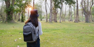 Üniversiteden genç öğrenciler parkta gezintiden zevk alıyorlar ve ilginç bir şey gördüklerinde bir şeye bakıyorlar. Eğitim, eğitim, üniversite, üniversite, mezuniyet konsepti.