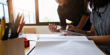 İş mühendisi ve ortakları kalem tutarken inşaat çizimi yapıyorlar. İş mühendisi ve ortakları planla tartıştılar. mühendislik konsepti için danışmanlık planı.