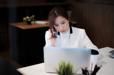 Danışman ortak sorunları çözmek için iş ortaklarıyla cep telefonuyla konuşuyor. Bankacı müşteriye banka hizmetleri hakkında tavsiyede bulunacak.