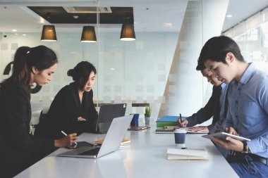 Dizüstü bilgisayarla yatırım borsasını araştıran ve analiz eden bir grup Fon yöneticisi.