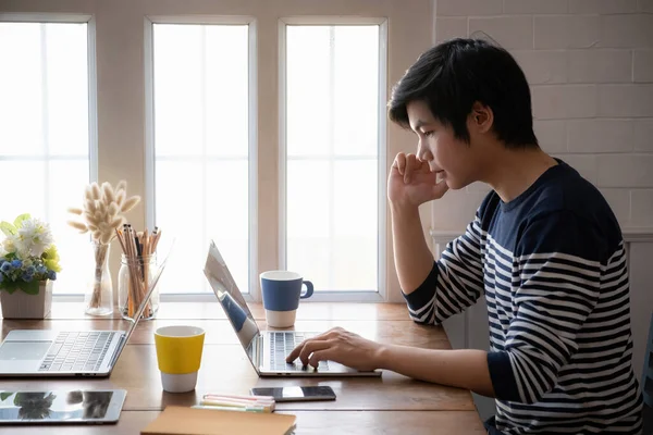 Asiático homem estudante foco aprender curso on-line e assistir vídeo tutorial via computador portátil na sala de estar em casa,. conceito de sala de aula online. — Fotografia de Stock