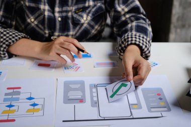 Evdeki oturma odasında cep telefonu uygulaması arayüzü hakkında erkek video geliştirici ve ui tasarımcısına yakın çekim. Yaratıcı dijital geliştirme ajansı kavramı.