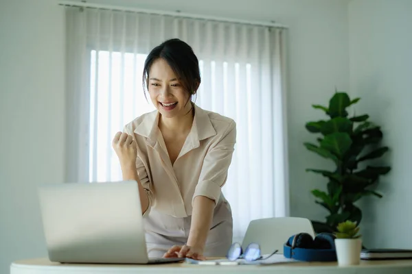 사무실에서 함께 회의를 하고 노트북 컴퓨터 화면에서 성공을 신나게 하는 사업가 여성. — 스톡 사진