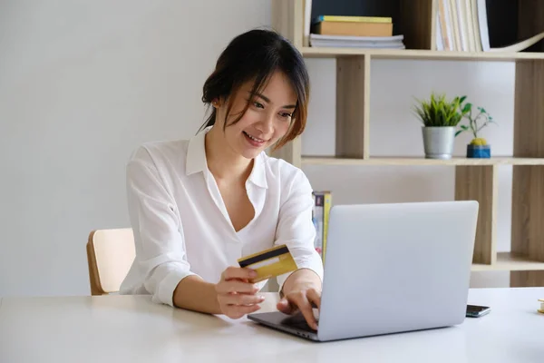 Mujer disfrutar con la aplicación de compras en línea y mirando a la computadora portátil para llenar el número de tarjeta de crédito para el pago. — Foto de Stock