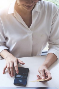 Ev, vergi ve fatura ödemek için mobil bankacılık uygulaması kullanan bir kadın