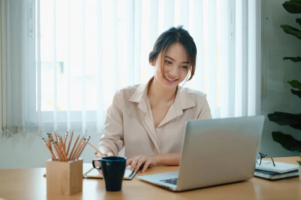 Una donna gioiosa si concentra su un webinar sul suo computer portatile. — Foto Stock