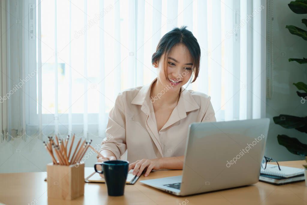 A joyful woman concentrates on a webinar on her laptop computer.