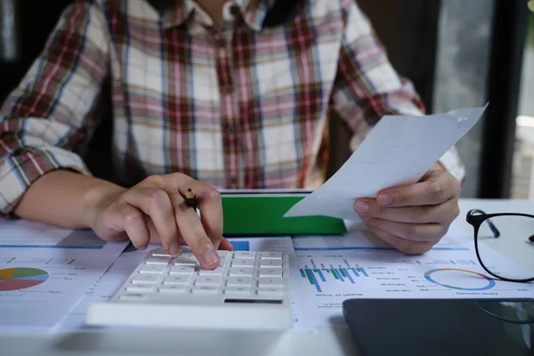 Bir adam borçlarını hesaplıyor, yönetiyor ve maliyet faturasını tutuyor..