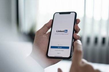 CHIANG MAI, THAILAND, 10 Haziran 2021: Ekranda LinkedIn uygulaması olan bir erkek Apple iPhone X tutuyor. LinkedIn akıllı telefonlar için bir fotoğraf paylaşım uygulaması.