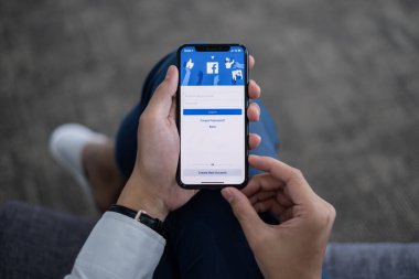 Chiang Mai Tayland. 10 Haziran 2021. Ekranda Facebook uygulaması olan bir adam iPhone 'u tutuyor. Facebook akıllı telefonlar için fotoğraf paylaşım uygulaması.
