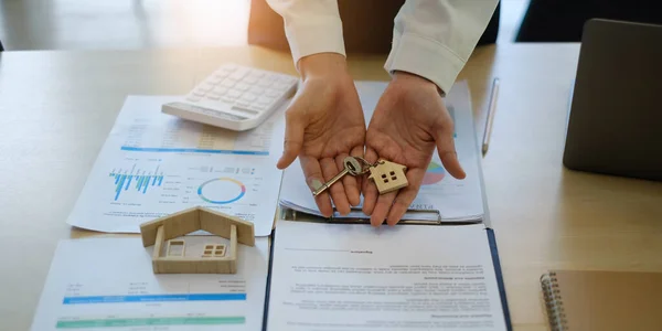 Fastighetsmäklare agent med hus modell och kontrakt innan träffa kunden. Fastighetskoncept. — Stockfoto