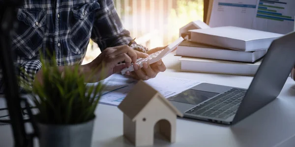 En man med sparkonto beräknar hur mycket pengar han kan spara i år. Fastigheter och konton eller sparpengar eller försäkringskoncept. — Stockfoto