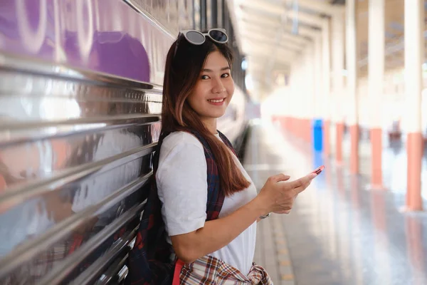 Afbeelding van Young freelance werken op het station voor de reis en sociale afstandsymbool op de bank. werk- en reisconcept — Stockfoto