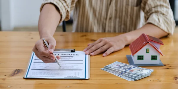 Following a deal with a broker, A Man signs a contract to rent a house. — Stockfoto