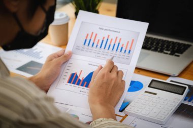 Yılın yarısından sonra bir fon yöneticisi, pazarlamanın finansal tablosunu evrak işleriyle inceliyor.