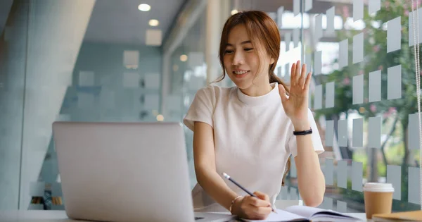 Jonge vrouwelijke college neemt notities en met behulp van highlighter. Gericht student in online klas kamer. Authentiek onderwijsconcept. — Stockfoto