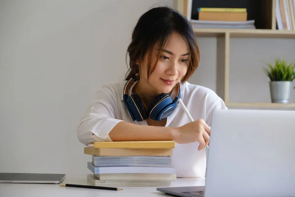 Vrolijke jonge Aziatische vrouw met laptop computer thuis. Studenten vrouw in de woonkamer. online leren, studeren, online winkelen, freelance, aziatisch concept — Stockfoto