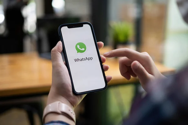 CHIANG MAI, THAILAND - JULY 15 2021 : Man holding a iPhone and open appstore searching social Internet service WhatsApp on the screen. iPhone was created and developed by the Apple inc. — Stock Photo, Image