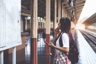 Yanlız turist tren istasyonunda sırt çantasıyla haritaya bakıyor. iş ve seyahat yaşam tarzı konsepti.