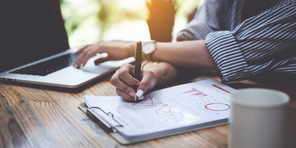 Busy business woman adviser working on wooden dest at her office with analyze paperwork. Financial, tax, accountant concept.