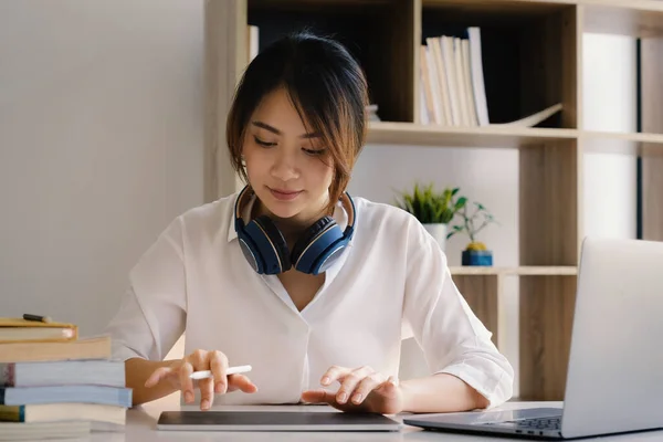 Vrolijke jonge Aziatische vrouw met behulp van digitale tablet thuis. Studenten vrouw in de woonkamer. online leren, studeren, online winkelen, freelance, aziatisch concept — Stockfoto