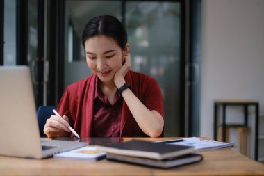 Tabletle çalışan neşeli Asyalı kadın. Öğrenci kadın oturma odasında. çevrimiçi öğrenim, öğrenim, çevrimiçi alışveriş, serbest çalışma, asean konsept