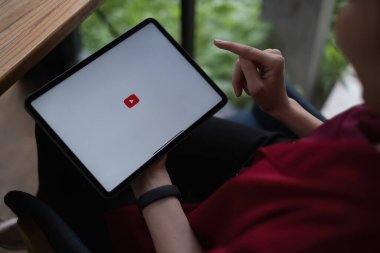 Chiang Mai, Tayland - AUG 09, 2021: YouTube Premium 'a bağlanmak için tablet kullanan kadın. YouTube, google 'ın bir video paylaşım sitesidir.