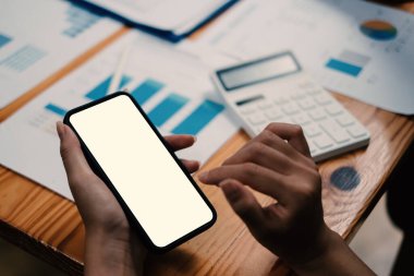 Kafede boş ekranlı akıllı telefon gösteren Asyalı bir kadın. Reklamınız için boş ekran.