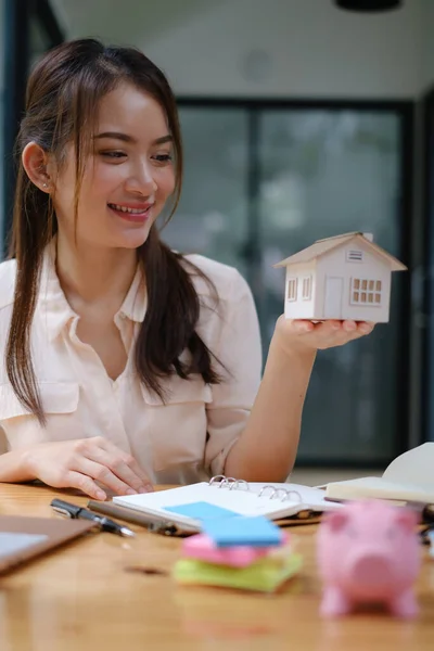 Ένας κτηματομεσίτης επιδεικνύει το μοντέλο Σπίτι στους πελάτες που ενδιαφέρονται για την αγορά ασφάλισης σπιτιού. Η έννοια της ασφάλισης κατ 'οίκον και της περιουσίας. — Φωτογραφία Αρχείου
