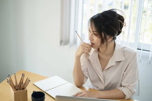 Asiatisk affärskvinna sitter på kontoret med bärbar dator på trä skrivbord — Stockfoto