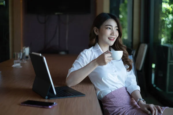 İş kadını, teknik fiyat grafiğini ve elinde kahve fincanı olduğunu gösteren göstergeyi analiz etmeye çalışıyor.. — Stok fotoğraf