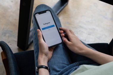 CHIANG MAI, THAILAND - SEP 07, 2021: iPhone 'da Instagram uygulaması kullanan bir kadın. Kısa video yapmak için Instagram makaraları