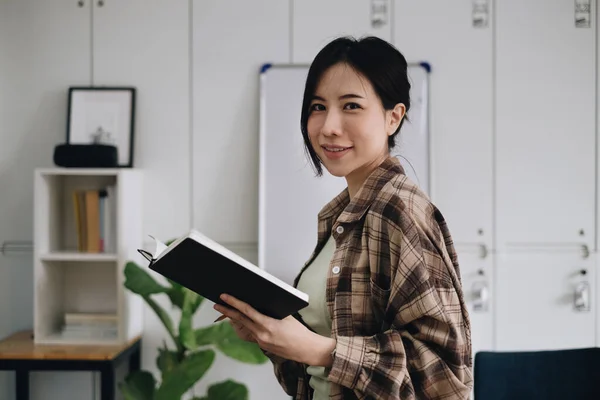 Porträtt av glad asiatisk kvinna med ledigt liv på skrivbordet på hemmakontoret. Begreppet unga företagare som arbetar hemma — Stockfoto